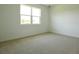 Bright bedroom features a large window and neutral carpeting, ready for your personal touch at 828 Lake Dell Rd, Dundee, FL 33838