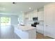 Open-concept kitchen featuring white cabinetry, stainless steel appliances, a spacious island, and seamless access to living areas at 828 Lake Dell Rd, Dundee, FL 33838