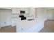 Clean and bright kitchen featuring a large island with quartz countertops, stainless steel sink, and easy access to dining area at 828 Lake Dell Rd, Dundee, FL 33838