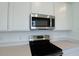 Modern kitchen showcasing stainless steel microwave and range appliances against bright white cabinets and quartz countertops at 828 Lake Dell Rd, Dundee, FL 33838
