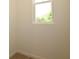 Close-up of a bright window offering natural light into a room with beige walls and tile flooring at 828 Lake Dell Rd, Dundee, FL 33838