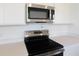 Close-up of a kitchen with stainless steel appliances, quartz countertops, and sleek white cabinetry at 832 Lake Dell Rd, Dundee, FL 33838