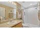 Bright bathroom with a single sink vanity and a walk-in shower with tiled walls at 1150 Jade East Ln, Kissimmee, FL 34744