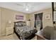 Inviting bedroom featuring a floral-patterned comforter, dark curtains, and neutral walls at 1150 Jade East Ln, Kissimmee, FL 34744