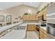 Kitchen boasts stainless appliances, tile backsplash, counter seating, and light wood cabinetry at 1150 Jade East Ln, Kissimmee, FL 34744