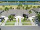 Aerial view of multi-unit homes, landscaping, and a lake at 127 Club Villas Ln, Kissimmee, FL 34744