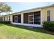 Backyard featuring a green lawn, trimmed hedges, and screened patios at 127 Club Villas Ln, Kissimmee, FL 34744
