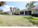 Backyard featuring a green lawn, trimmed hedges, and screened patios at 127 Club Villas Ln, Kissimmee, FL 34744