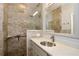 Bathroom featuring a glass shower, accessible features, and updated sink at 127 Club Villas Ln, Kissimmee, FL 34744
