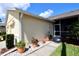 Exterior of home with a screened porch, beautiful landscaping, and walkway with potted plants at 127 Club Villas Ln, Kissimmee, FL 34744