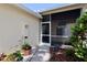 Exterior featuring a screened porch, sidewalk, and landscaping with potted plants in natural light at 127 Club Villas Ln, Kissimmee, FL 34744