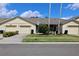 Charming villa-style home with a well-maintained lawn and a beige exterior at 127 Club Villas Ln, Kissimmee, FL 34744