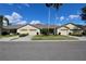Charming villa-style home with a well-maintained lawn and a beige exterior at 127 Club Villas Ln, Kissimmee, FL 34744