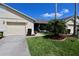 Beautifully landscaped lawn with mulch beds, palm trees, and a sidewalk path at 127 Club Villas Ln, Kissimmee, FL 34744