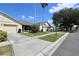 View of a one-story villa featuring mature landscaping, palm trees and green lawns at 127 Club Villas Ln, Kissimmee, FL 34744