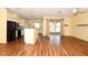 A spacious living room with laminate wood flooring and a kitchen in the background at 127 Club Villas Ln, Kissimmee, FL 34744