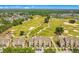 An aerial view of homes nestled near a golf course, with lush trees and a nearby pond at 1311 Seven Eagles Ct # 202, Reunion, FL 34747