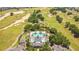 Scenic aerial view of a community pool and clubhouse surrounded by a golf course at 1311 Seven Eagles Ct # 202, Reunion, FL 34747