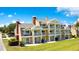 Three-story home with multiple balconies, white pillars, manicured lawn, and blue skies at 1311 Seven Eagles Ct # 202, Reunion, FL 34747