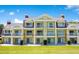 Three-story building showcasing multiple balconies, and a well-manicured lawn in the front at 1311 Seven Eagles Ct # 202, Reunion, FL 34747