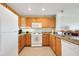 Bright kitchen featuring wood cabinets, tile flooring, and a view into the adjacent living area at 1311 Seven Eagles Ct # 202, Reunion, FL 34747