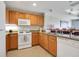 Well-lit kitchen featuring wood cabinetry, granite countertops, and modern appliances at 1311 Seven Eagles Ct # 202, Reunion, FL 34747