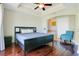 Serene main bedroom featuring hardwood floors, patterned accent wall, and a glimpse into the en-suite bathroom at 1311 Seven Eagles Ct # 202, Reunion, FL 34747