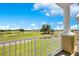 Beautiful golf course view from the balcony, featuring lush greenery and a clear blue sky with clouds at 1311 Seven Eagles Ct # 202, Reunion, FL 34747