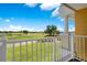Balcony view overlooking the golf course, showcasing vibrant green grass and a bright, partly cloudy sky at 1311 Seven Eagles Ct # 202, Reunion, FL 34747