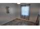 Cozy bedroom with a decorative mirror, neutral walls, modern ceiling fan, and large window with privacy blinds at 15106 Sw 38Th Cir, Ocala, FL 34473
