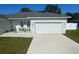 Charming single-story home featuring a two-car garage, modern exterior lighting, and a well-manicured lawn at 15954 Sw 55Th Avenue Rd, Ocala, FL 34473