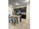 Modern kitchen with stainless steel appliances, dark cabinets, and a kitchen island with granite countertops at 15954 Sw 55Th Avenue Rd, Ocala, FL 34473