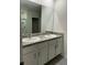 Bathroom featuring a double vanity with a granite countertop, white cabinetry, and a large mirror at 167 Eagleview Loop, Davenport, FL 33837