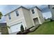 New construction home with a two-car garage, complemented by lush landscaping, and a well-manicured lawn at 167 Eagleview Loop, Davenport, FL 33837