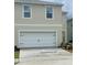 A modern home showcasing a white garage door against a light beige exterior, featuring well-placed windows at 167 Eagleview Loop, Davenport, FL 33837