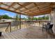 Wide-angle of a covered back porch with wooden floors, an array of seating, and a lovely view of the backyard at 18806 Monroe Ave, Orlando, FL 32820
