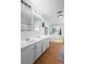 Bathroom featuring dual sinks, large mirrors, bathtub, and hardwood floors offering a spa-like experience at 18806 Monroe Ave, Orlando, FL 32820