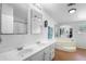 Bathroom featuring dual sinks, large mirrors, bathtub, and hardwood floors offering a spa-like experience at 18806 Monroe Ave, Orlando, FL 32820