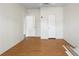 An empty bedroom showcases hardwood floors with two doors and one closet, offering spacious living at 18806 Monroe Ave, Orlando, FL 32820