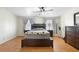 Main bedroom featuring a ceiling fan, two windows, hardwood floors and warm natural light at 18806 Monroe Ave, Orlando, FL 32820