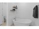 Elegant bathroom featuring a soaking tub and floating wood shelves at 19283 Allium Pl, Orlando, FL 32827