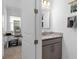 Stylish half bathroom featuring granite countertops, gray vanity, and views into an office space at 19283 Allium Pl, Orlando, FL 32827