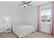 Bright bedroom with pink curtains, carpet, and a patterned bedspread offers a cozy and inviting space at 19283 Allium Pl, Orlando, FL 32827