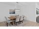 Bright dining room with modern light fixture, dining table and six chairs at 19283 Allium Pl, Orlando, FL 32827