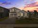 Charming two-story home with a well-manicured lawn, a two-car garage, and colorful sunset at 19283 Allium Pl, Orlando, FL 32827
