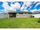Backyard of home with lush green grass, screened porch, white fence, and cloudy skies at 2059 Dexter St, Haines City, FL 33844
