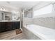 Bright bathroom with soaking tub, glass shower, and dual sink vanity with dark wood cabinets at 2059 Dexter St, Haines City, FL 33844