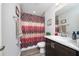 Bathroom featuring shower with decorative curtain, single sink vanity, and modern light fixture at 2059 Dexter St, Haines City, FL 33844