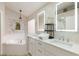 Elegant bathroom featuring double sinks, modern mirrors, and a soaking tub at 2735 Lido Key Dr, Kissimmee, FL 34747