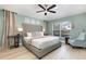 Well-lit bedroom with large bed, ceiling fan, and backyard view through the window at 2735 Lido Key Dr, Kissimmee, FL 34747